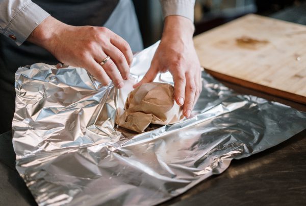 Person in Grey Shirt Packing a Product