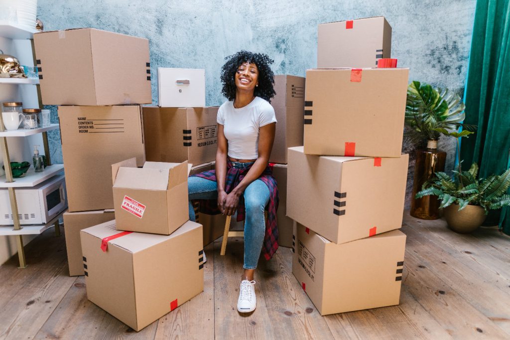 Woman sitting beside cardboard boxes