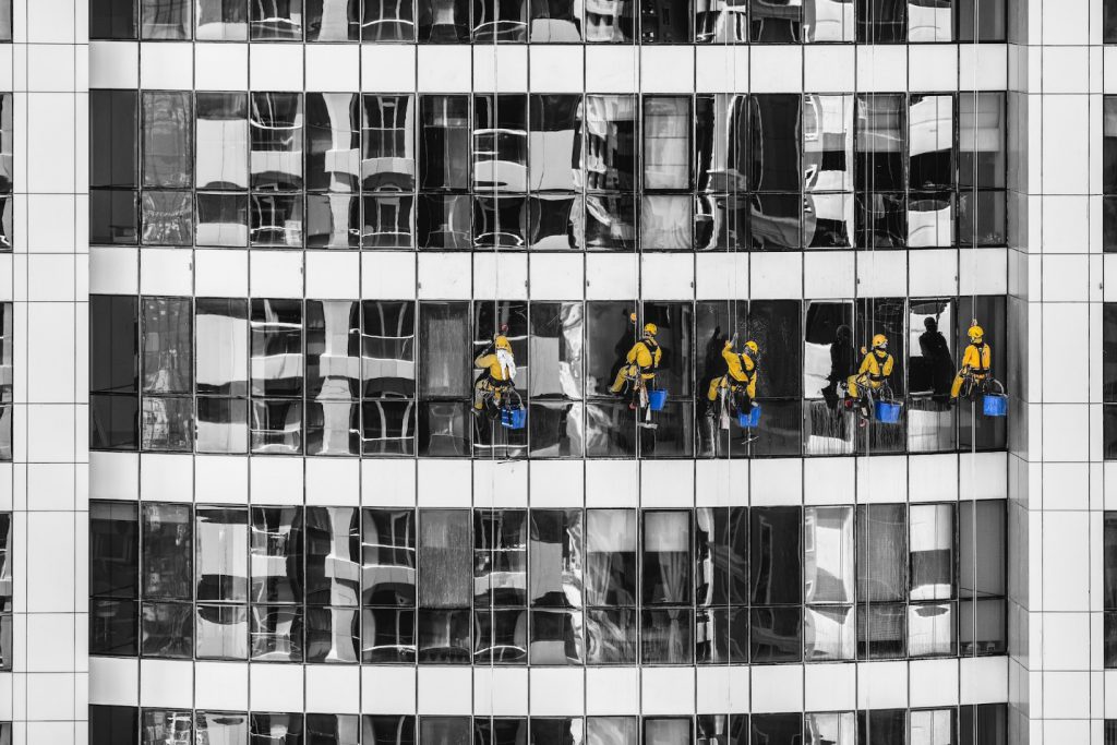 Five Unknown People Cleaning Glass Building